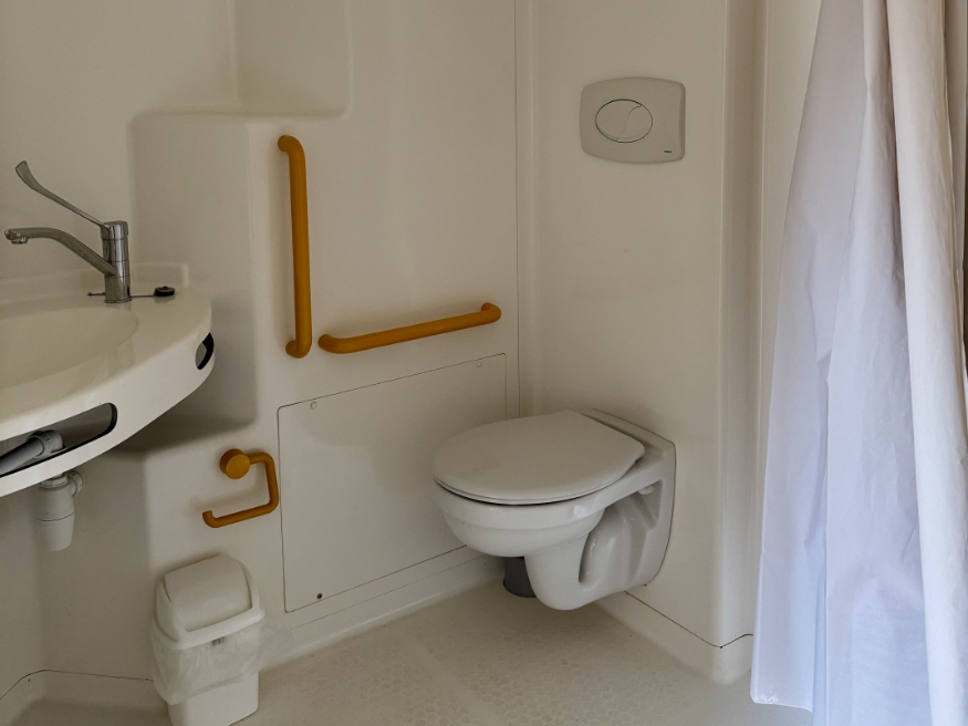 Bathroom with toilet in the PMR chalet with wooden terrace and garden furniture, available to rent at the 3-star Le Paquier Fané campsite in Chagny, Saône-et-Loire.