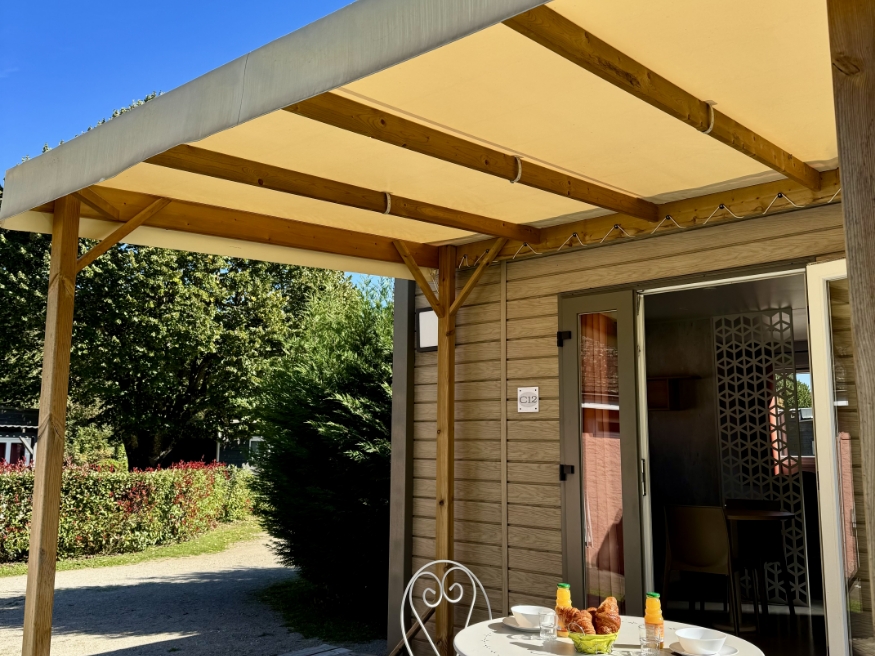 Semi-covered wooden terrace at the chalet, available to rent at the 3-star Le Paquier Fané campsite in Bourgogne-Franche-Comté