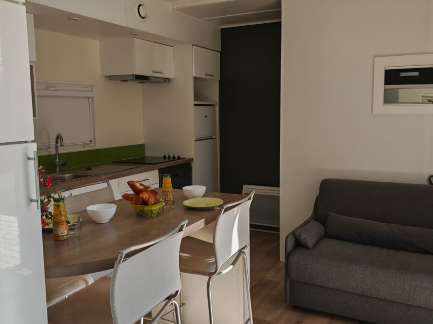 Kitchen area of the Grand Large mobile home, available for rent at Le Paquier Fané campground in Bourgogne-Franche-Comté