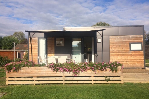 Exterior view of the luxury mobile home available for rent at Le Paquier Fané campground in Bourgogne-Franche-Comté