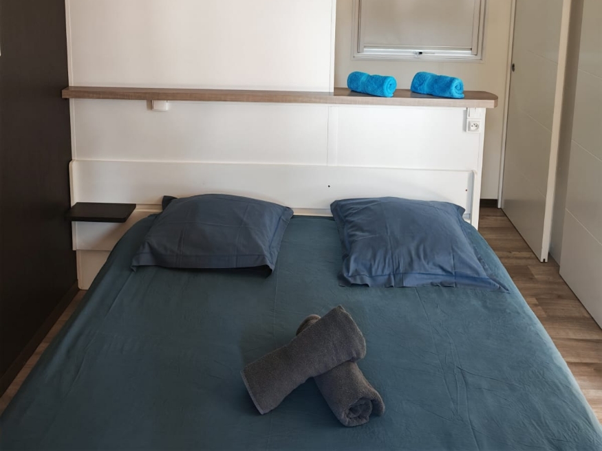 Bedroom with double bed in the TAOS luxury mobile home, available for rent at Le Paquier Fané campground in Saône-et-Loire