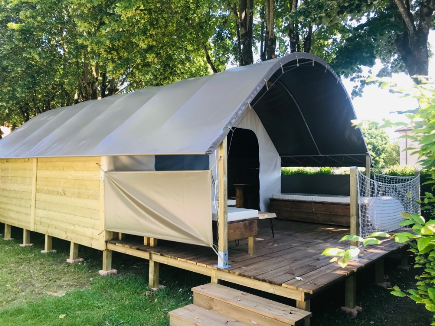 Wooden terrace with railing at the unique Safari tent accommodation in Saône-et-Loire, available for rent at the 3-star Le Paquier Fané campground in Chagny.